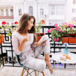chica desayunando en el balcón