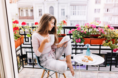 chica desayunando en el balcón