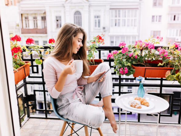chica desayunando en el balcón